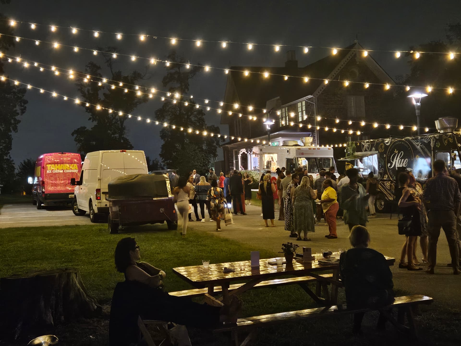 Outdoor evening event under string lighting